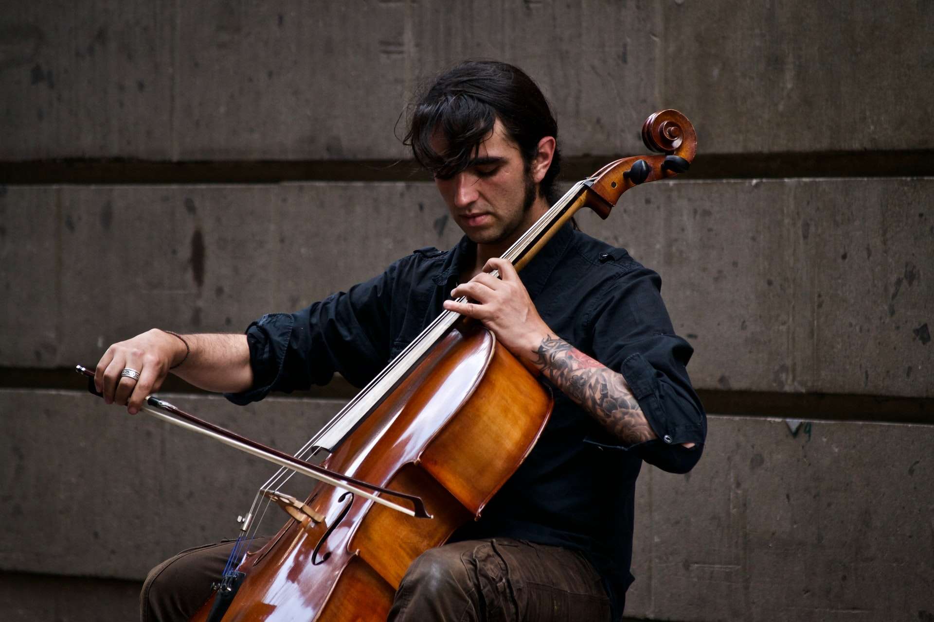 Un violoncelliste à une annonce musicien pour jouer dans un conservatoire du violoncelle, assis sur une chaise dos au mur.