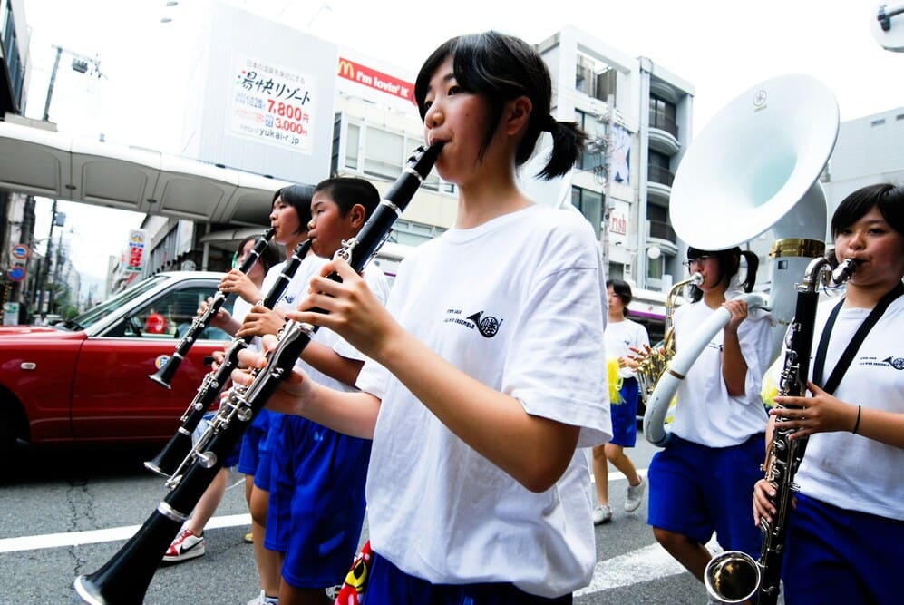 Une membre de fanfare joue de la clarinette dans la rue.