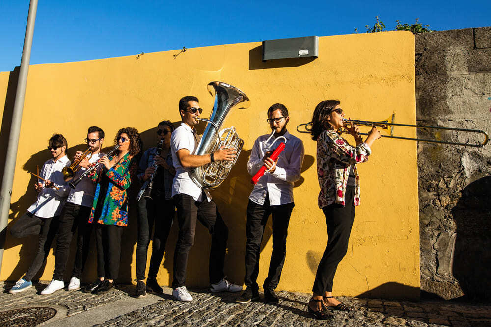 Une membre de fanfare joue du tuba devant un mur jaune.