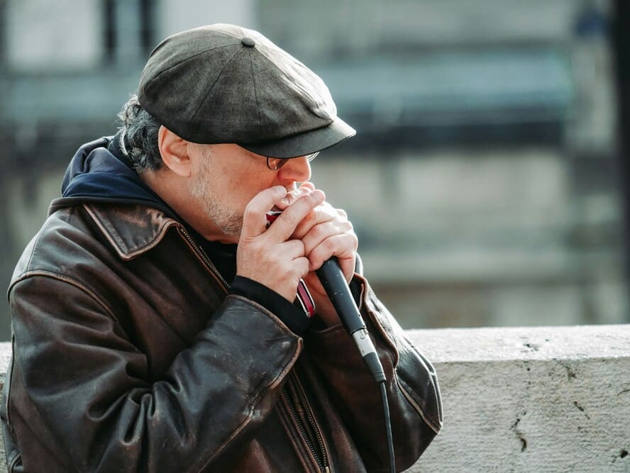 Un homme joue de l'harmonica.