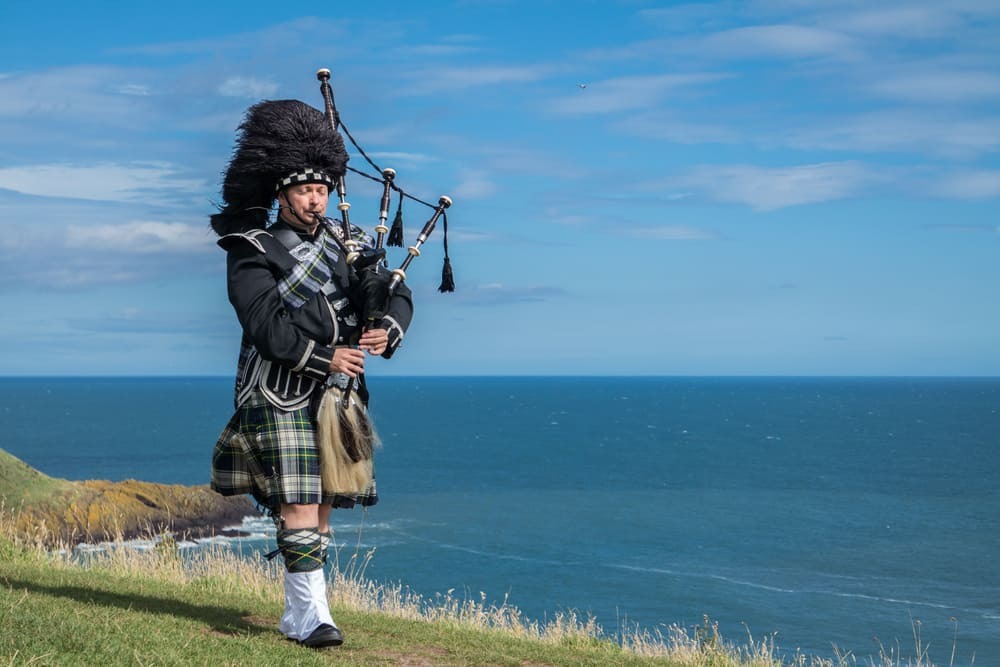 Un homme joue de la cornemuse en kilt traditionnel.