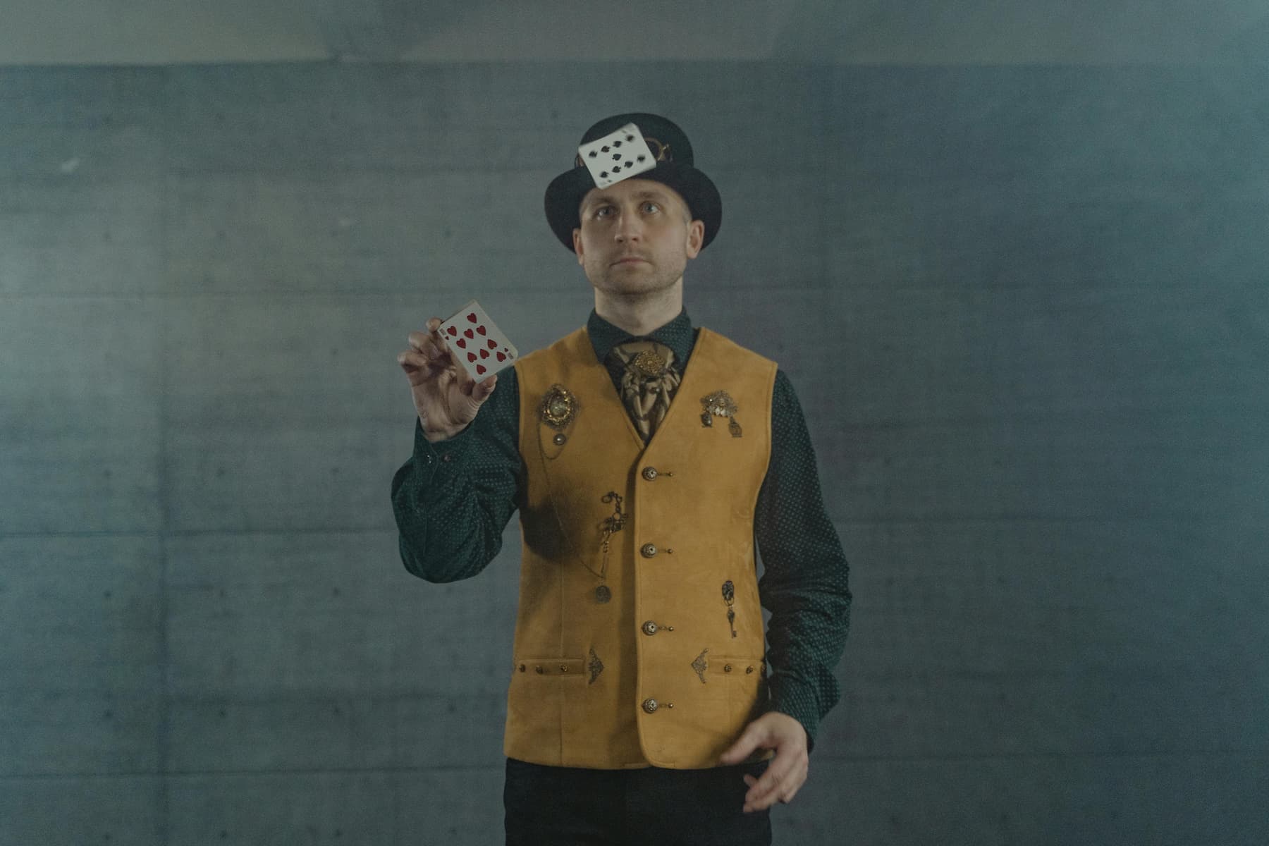 Magicien en tenue de scène présentant un jeu de cartes