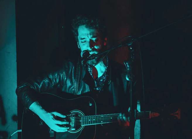 Plan concert d’un guitariste et chanteur en train de jouer son premier concert sur scène.