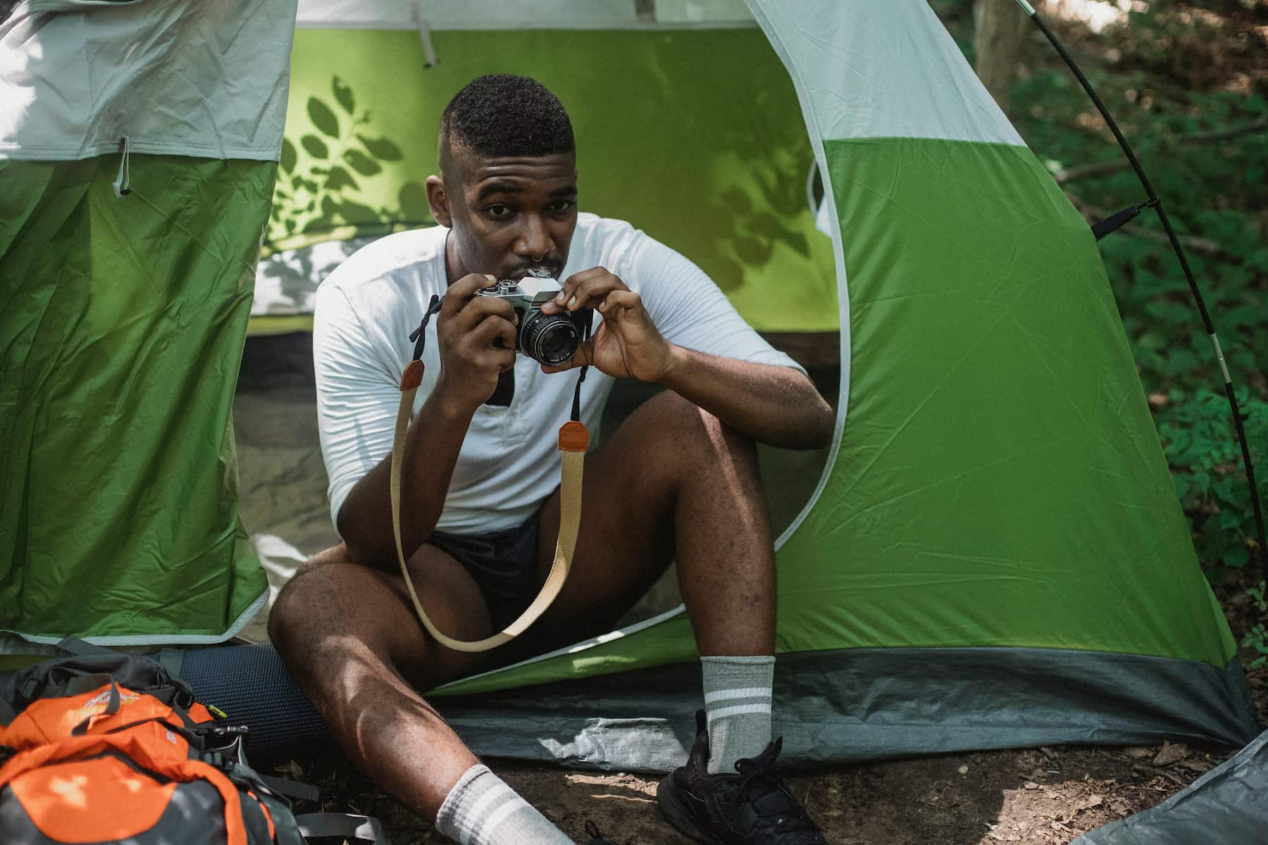 Homme prenant une photo dans sa tente de camping