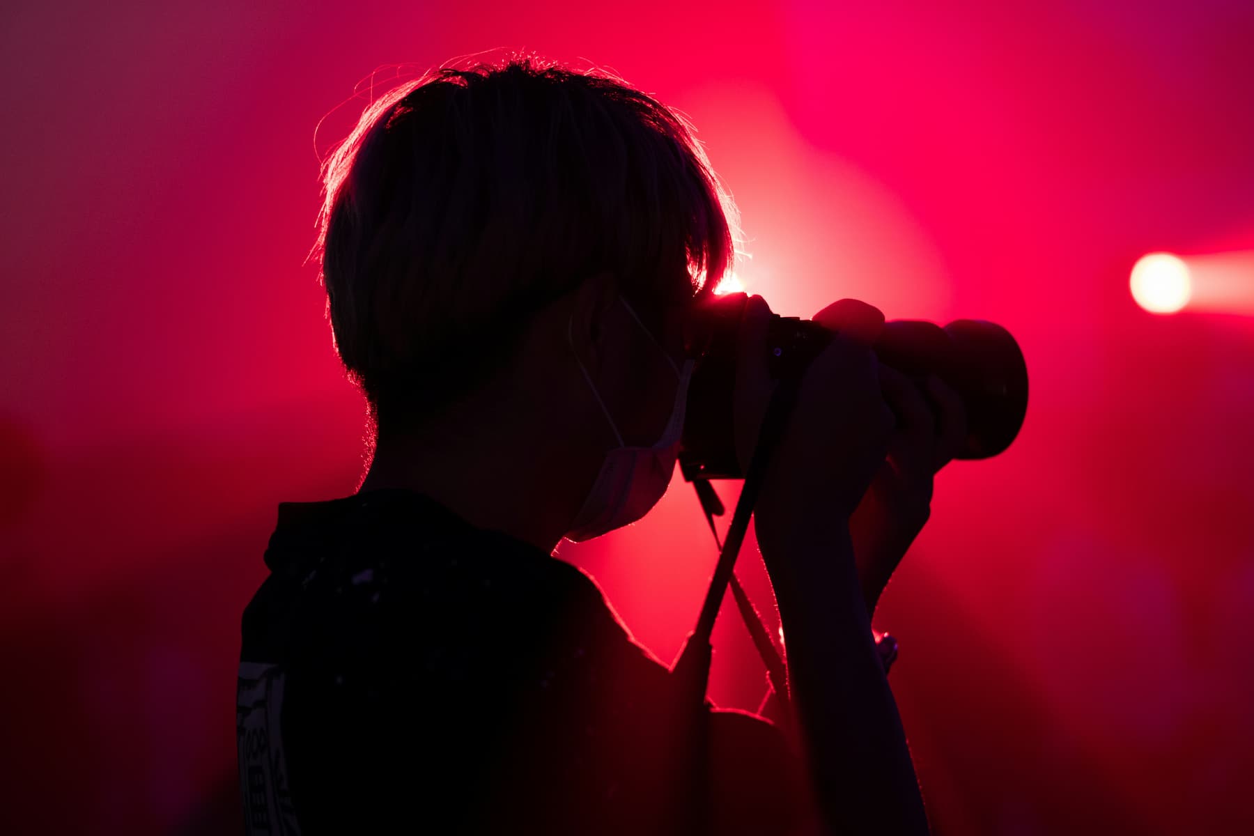 Homme faisant des photos sous les projecteurs d'un spectacle