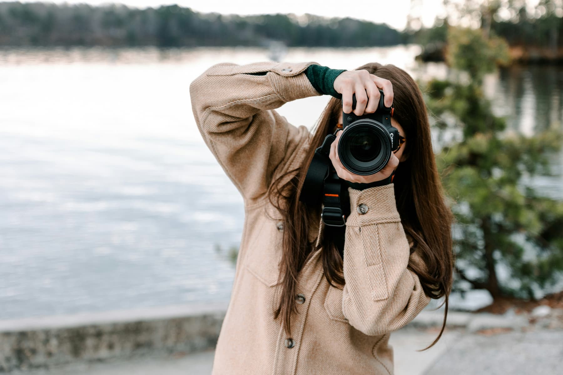 Une femme faisant des photos au bord d'un lac