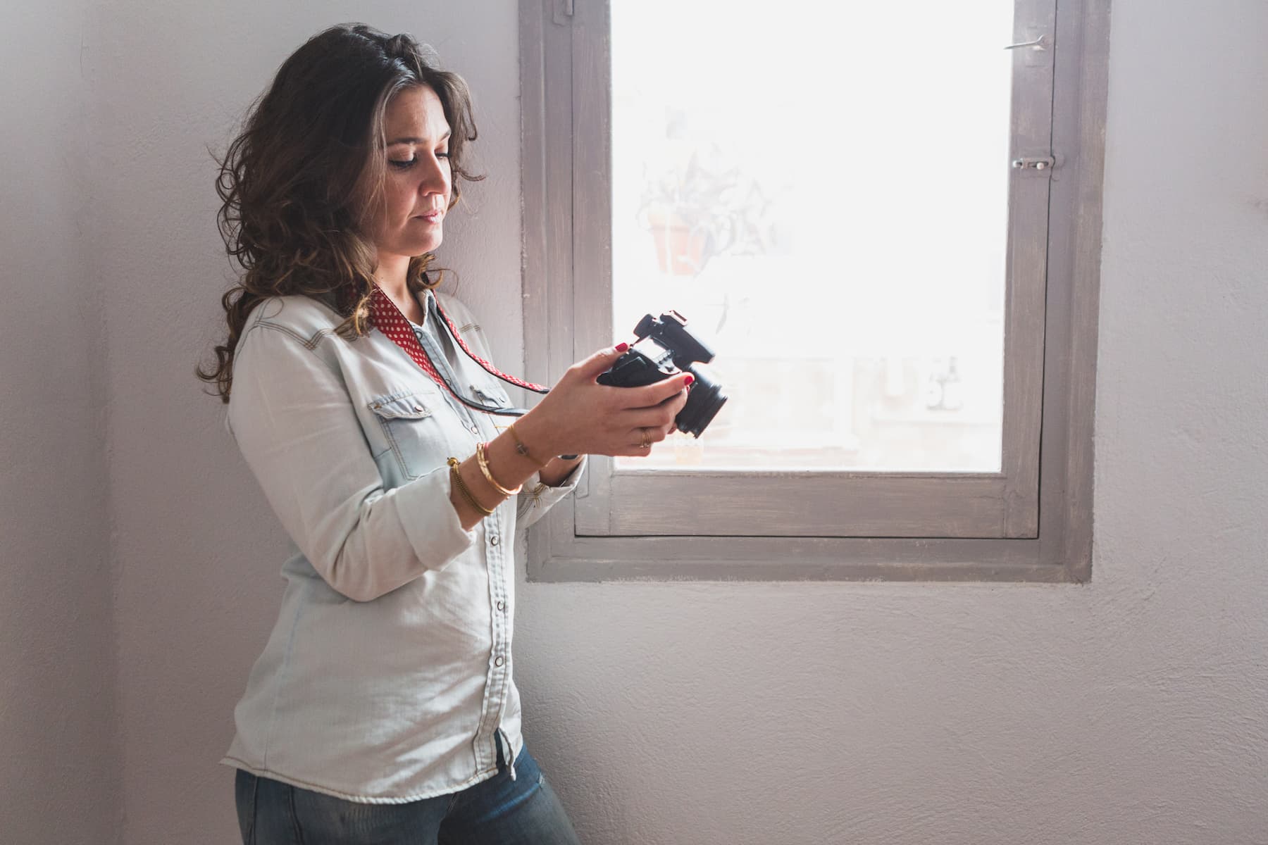Femme regardant les photos à côté de la fenêtre