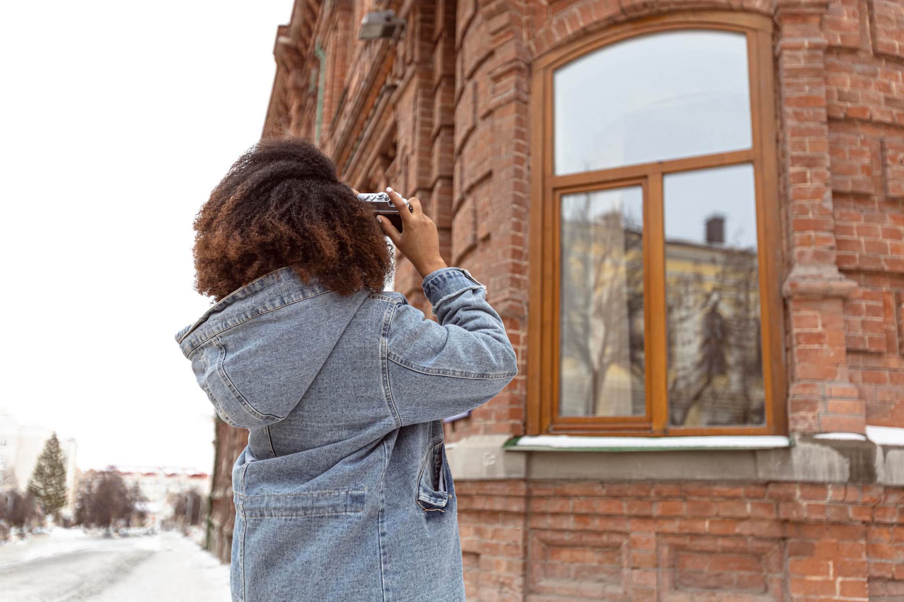 Plan moyen d'une femme prenant des photos d'un immeuble