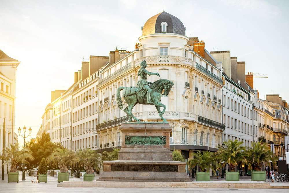 Photo d'une statue et de bâtiments de lav ville d'Orléans en région Centre-Val-de-Loire.